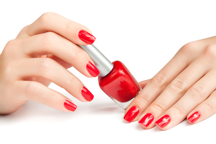 Hands with red manicure and nail polish bottle isolated